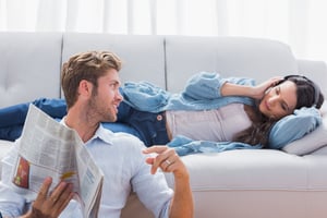 Couple relaxing in the living room listening to music and reading a newspaper-1