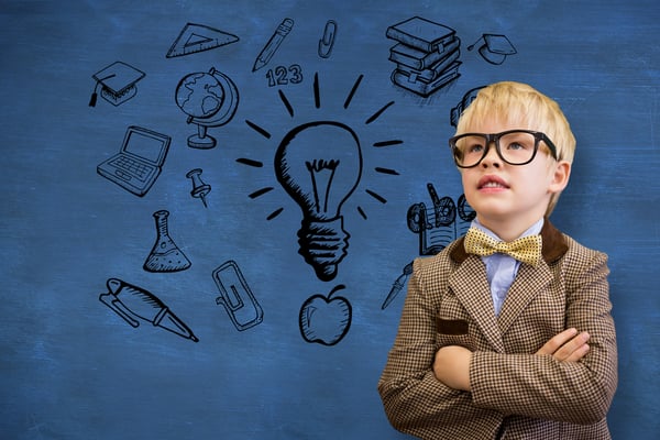 Cute pupil dressed up as teacher against blue chalkboard