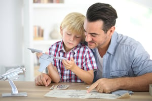 Father and kid making a plane model