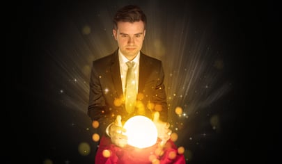 Gorgeous businessman sitting with sparkling magic ball in his lap