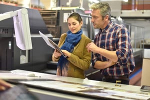 Man in printing house showing client printed documents-1