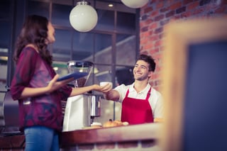 Smiling waiter serving a client at the coffee shop.jpeg