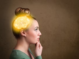 Young girl thinking with glowing brain illustration on grungy background.jpeg
